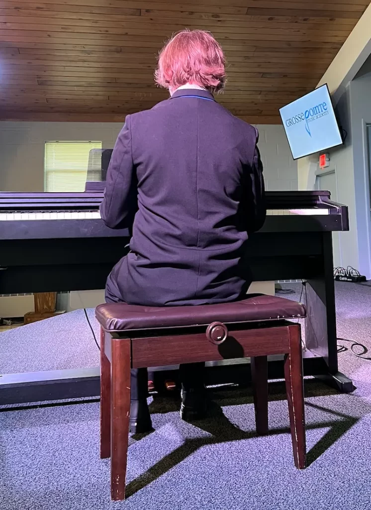 piano player performing live at grosse pointe music academy recital.